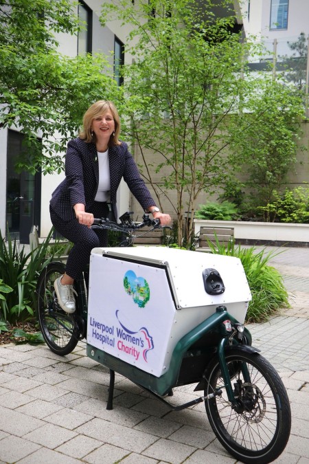 Minister for Local Transport Lilian Greenwood, sat on a bike in a garden area at the Royal.