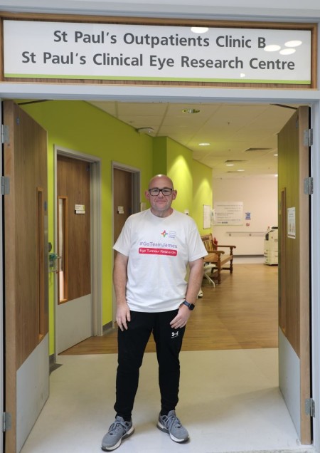 James proudly stands underneath the St Paul's Outpatient Clinic sign sporting a LUHFT charity t-shirt ahead of his fundraising effort.